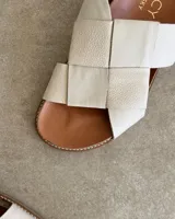 Sandalias bajas de cuero negro con tiras anchas cruzadas y plantilla anatómica color camel.