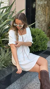 Vestido corto blanco de corte evasé, con escote cuadrado y mangas cortas abullonadas.