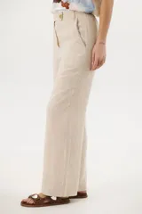 Pantalón de lino azul de corte palazzo con botón decorativo en la cintura.