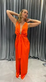 Vestido largo color naranja, sin mangas, con escote en V y abertura en la pierna.