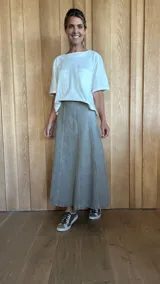 Pollera larga de denim color celeste, corte evasé y paneles verticales.