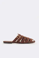 Sandalias planas de cuero color marrón con diseño de tiras entrecruzadas y hebilla lateral ajustable.