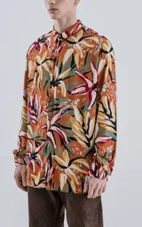 Camisa de manga larga con estampado de flores y hojas en tonos naranja, blanco, rojo, verde y negro.