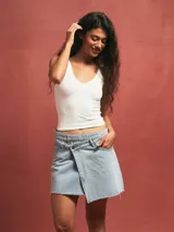 Minifalda celeste de denim con diseño cruzado y ruedo desflecado.