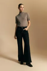 Jean oxford de tiro alto, color azul oscuro, con costuras frontales marcadas y corte acampanado progresivo desde la rodilla.