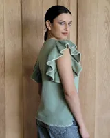 Musculosa blanca de punto con cuello redondo y mangas con volados.
