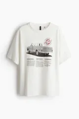 Remera blanca de corte amplio con estampado de camioneta Chevrolet y texto de General Motors.