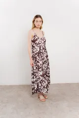 Vestido largo con estampado animal print tipo vaca en tonos marrones y blancos. Tiene breteles finos y corte suelto.