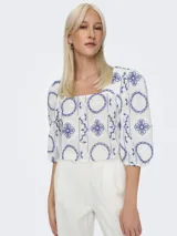 Top corto blanco con estampado de flores azules, cuello cuadrado y mangas cortas abullonadas.
