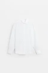 Camisa blanca de lino, corte regular, con cuello solapa, manga larga con puños abotonados y cierre frontal con botones.