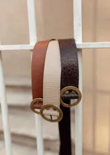 Cinturón negro de cuero con hebilla circular dorada.