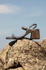 Sandalias plateadas de cuero con taco medio bloque y punta cuadrada. Tiras con apliques de tachas esféricas.