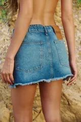 Minifalda de denim azul con ruedo desflecado, bolsillos delanteros y traseros, avíos metálicos RENÉE y badana de PU.