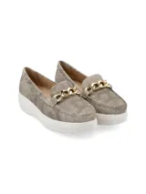 Mocasín de cuero charol negro con plataforma blanca y detalle de hebilla metálica plateada en el empeine.