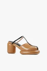 Mule color caramelo con plataforma y taco cilíndrico, tira superior negra y puntera cuadrada.