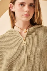 Campera con capucha color beige, de punto inglés con terminaciones rotas en los puños y bordado artesanal en la espalda con motivos marinos.