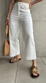 Pantalón capri blanco de tiro alto, corte recto y detalle de costuras onduladas en los bolsillos delanteros.