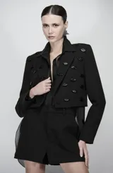 Blazer cropped negro con bordado en relieve de labios esmaltados, silueta recta y largo mini.