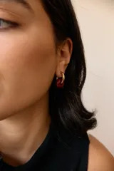 Aros de acero quirúrgico hipoalergénico con piedras naturales azules. Diseño de aro con dije circular colgante.