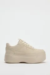 Zapatillas deportivas color beige con plataforma de 6 cm y cierre con cordones.
