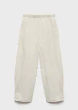 Pantalón de tiro medio color beige, estilo jogger con diseño balloon, cintura elástica, pinzas en el bajo y forro interior.