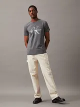 Remera gris de corte slim fit con cuello redondo y manga corta. Estampado frontal con el monograma de Calvin Klein Jeans en blanco y celeste.