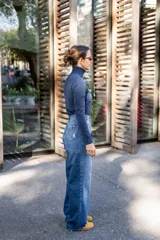 Pantalón de jean celeste de corte recto, con detalles de apliques desflecados en los bolsillos delanteros y roturas en la pierna.