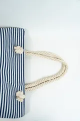 Bolso tipo tote con rayas horizontales rojas y blancas en la parte superior y base color beige. Asas de soga gruesa.