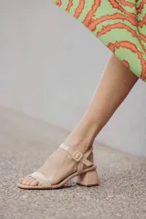 Sandalias de tacón bajo color beige con textura símil piel de serpiente. Tienen una tira delgada sobre los dedos y una pulsera con hebilla al tobillo.