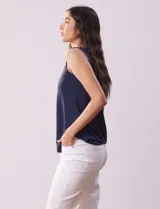 Blusa sin mangas en seda fría color blanco, marca Absolutely Famous. Escote en V con lazo entrelazado.