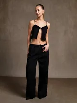 Top corto negro con breteles finos y detalle de volados en el escote.