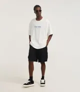 Bermuda masculina de poliéster, corte baggy, con cintura elástica ajustable con cordón y bolsillos cargo con cierre de cremallera.