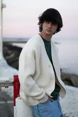 Cardigan de punto color crema con botones. Corte clásico y amplio.