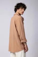 Camisa blanca de lino con cuello clásico, manga larga con puños abotonados y corte holgado. 