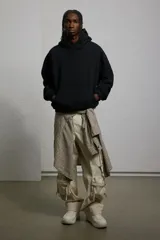 Canguro negro con capucha, corte holgado y bolsillo tipo canguro. Confeccionado en tejido de mezcla de algodón con interior cepillado suave. Remate acanalado en puños y bajo.