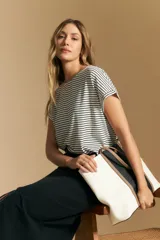 Remera de manga corta, color blanco con rayas horizontales negras, cuello redondo y calce holgado.