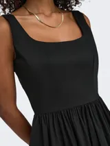 Vestido corto negro sin mangas, con tirantes finos, cintura marcada y falda con vuelo.