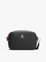 Bandolera negra de Tommy Hilfiger con monograma TH en relieve y logo dorado en el frente. Tiene correa ajustable y extraíble, cierre de cremallera, bolsillo interior con cremallera y monedero extraíble con cremallera.