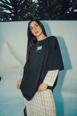 Remerón negro de corte amplio con estampa en la espalda con la palabra "RELAX" en letras blancas con efecto ondulado.
