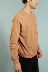 Sweatshirt color marrón claro con cuello redondo y puños ajustados.