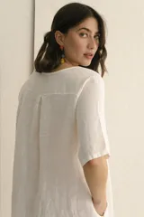 Vestido corto color arena, de lino, con escote en V y mangas cortas.