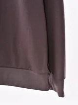Buzo negro de corte holgado, cuello redondo y mangas largas.