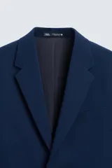 Blazer slim fit azul marino confeccionado en tejido con viscosa. Cuello con solapas de muesca, manga larga con puño abotonado, bolsillo de vivo en pecho y de solapa en cadera, bolsillo interior, bajo con aberturas en espalda y cierre frontal con botones.
