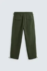 Pantalón verde militar de corte relaxed fit confeccionado en tejido técnico ligero. Cuenta con cintura elástica ajustable con cordón interior, bolsillos frontales y traseros con solapa, pliegues en las rodillas y bajo ajustable con elástico.