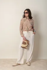 Pantalón ancho color beige de lino y rayón, con cintura elastizada ajustable con cordón y bolsillos laterales.