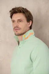 Remera tipo polo color beige, de manga corta y corte clásico. Tiene cuello con botones y está confeccionada en algodón.