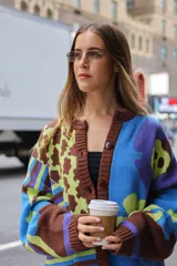 Cárdigan de punto con estampado floral en tonos celeste, verde, marrón y violeta. Tiene corte oversized y cierre frontal con botones.