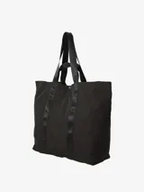 Bolso tote negro de Carhartt WIP, modelo Canby. Confeccionado en tafetán de nailon ligero, con compartimento principal con cierre de botón a presión, bolsillo interior con cremallera y bolsillo exterior. Asas de cincha resistentes y etiqueta cuadrada de Carhartt.