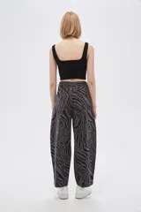 Pantalón de jean de tiro alto con estampado animal print de cebra en tonos borgoña y negro.