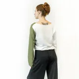 Blusa de mangas largas, con corte holgado y escote redondo. Presenta un diseño color block, con la mitad izquierda en color blanco y la mitad derecha en color verde oliva.